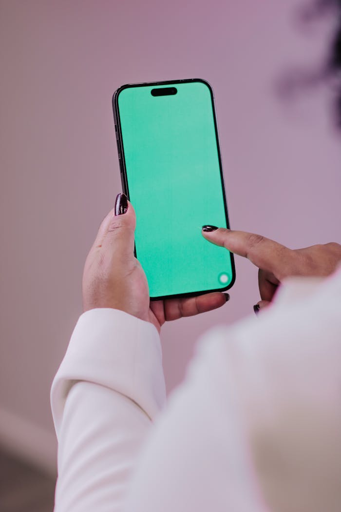 Crafting Captivating Headlines: Your awesome post title goes here Person using a smartphone with a green screen for editing or mockup purposes.